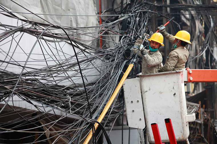 Officials are clearing up the area after a fire engulfed commercial buildings on Ratchawong Road near Sampeng market in Samphanthawong district, Bangkok, on Sunday. (Photo: Apichart Jinakul)