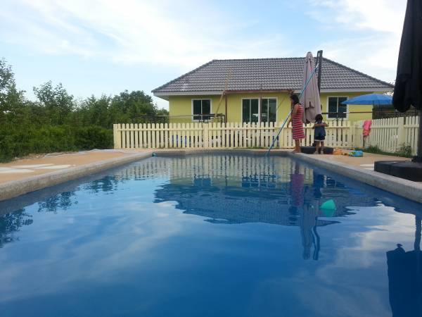 picture of pool and precast concrete house in background 2bed/bath delivered on a truck 100day install