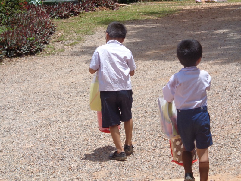 2 young kids going up the hill with their swag.