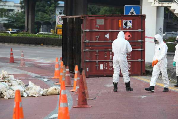 Hazmat officials handle a cargo container containing chemicals that fell from a truck near Suk Sawat Road in Bangkok last year. (File photo by Pawat Laopaisarntaksin)