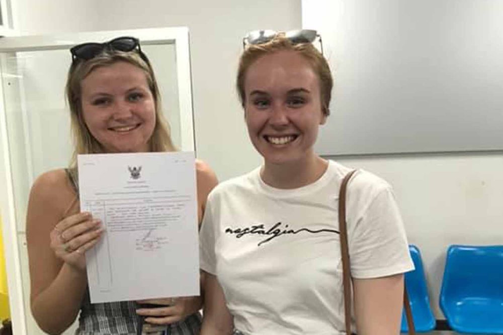 The two Australian tourists pose with their written complaint about being overcharged by a passenger van for a trip from Phuket airport to a Kata area hotel, at Karon police station in Phuket on Wednesday evening. (Photo supplied)