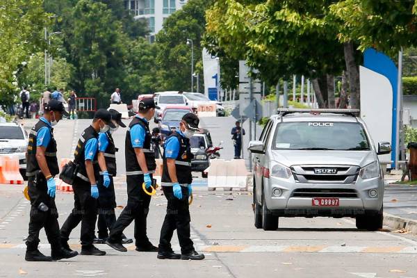 Bomb squad officers check the Government Complex on Chaeng Watthana Road after one of two bombs went off on Friday. (Photo by Pattarapong Chatpattarasill)