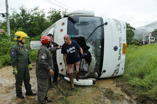 An Italian tourist exits the front of a bus after it overturned in Mae Tha district of Lampang province on Friday. (Photo by Assawin Wongnorkaew)