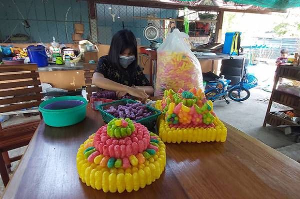 Orn, the 15-year-old girl was arrested on Nov 1 for making krathong floats featuring cartoon characters, makes more baskets with coloured bread for Monday's festival in Nakhon Ratchasima province. (Photo by Prasit Tangprasert)