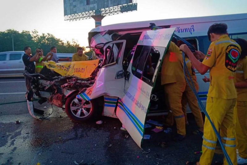 Rescue workers try to retrieve the dead and injured people from the wreckage of a passenger van after it rear-ended an 18-wheel trailer truck on the Bangkok-bound motorway in Chon Buri on Saturday morning. (Photo from Trikhunnatham.SoS rescue Facebook page)