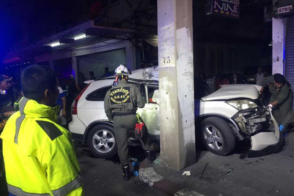 Rescue volunteers try to retrieve the body of the driver from the wreckage of his vehicle, which crashed into an electric pole near Kluay Nam Thai intersection in Klong Toey district early Thursday. (Photo taken from the Ruamkatanyu Foundation, Lotus Rama 3 point Facebook page)