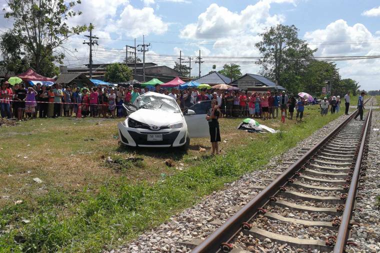 Onlookers stare at the wreckage of the Toyota Yaris near the rail crossing Hat Yai on Saturday. (Photo by Assawin Pakkawan)