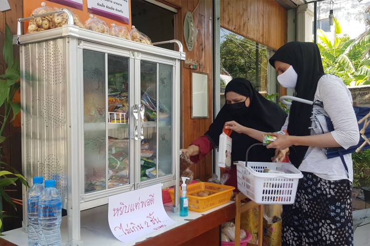 People place items in a community pantry in Muang district of Phitsanulok. The pantries have been found in 43 provinces as of Monday. (Photo by Chinnawat Singha)