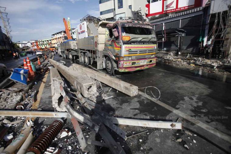Five power poles lie fallen on Sukhumvit 71 road, brought down by an 18-wheel trailer-truck, near Khlong Tan intersection in Suan Luang district shortly after midnight on Tuesday morning. (Photo: Nutthawat Wicheanbut)