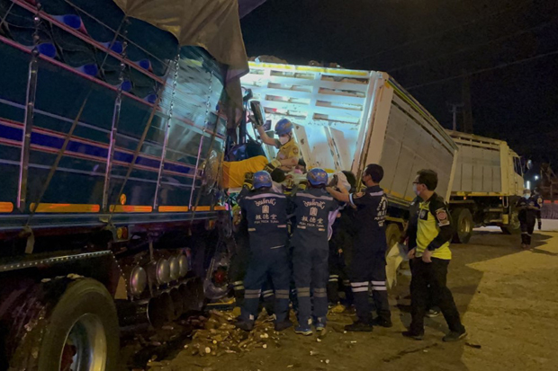 Rescuers try to extract the driver of a lorry that rear-ended another one in Bang Bo district of Samut Prakan on Sunday. (Photo: Sutthiwit Chayutworakan)