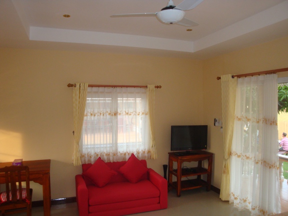 Inside a bungalow looking towards the table, sofa and 32&quot; TV.